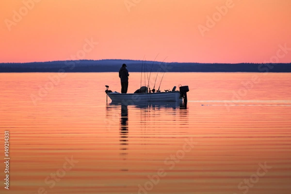 Obraz One man fishing from small boat at sunset