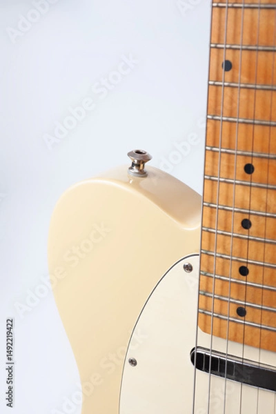 Obraz Six-string electric guitar, with a cream-colored wooden body and chrome-plated fittings.