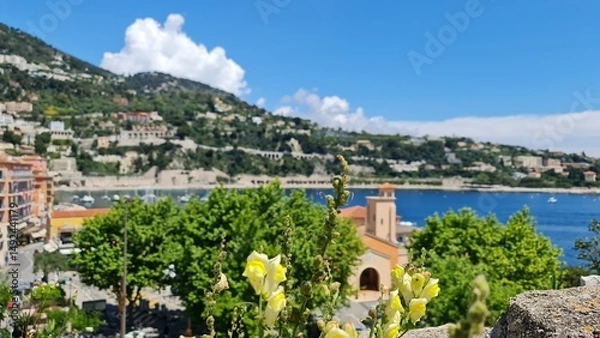 Fototapeta Villefranche-sur-Mer combines centuries-old stone walls, colourful gardens and panoramic views of the Mediterranean Sea and the colourful rooftops of the coastal town below.