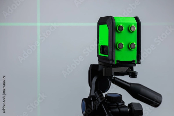Fototapeta Laser level meter green light measuring in construction site for interior decoration