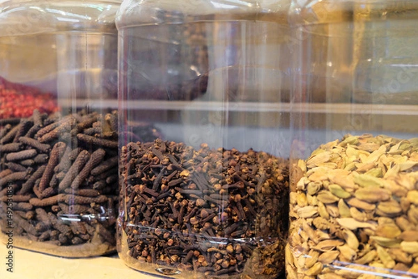Fototapeta A shelf that is filled to capacity with assorted jars of nuts and spices