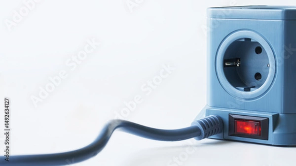 Fototapeta Blue cubic power strip featuring four euro sockets and an illuminated red switch, ideal for organizing and powering multiple home or office electronics without clutter. Photo. Copy space