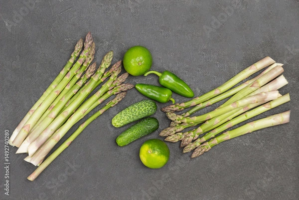 Fototapeta Asparagus, green peppers and cucumbers on table.