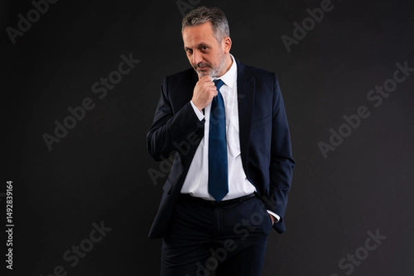 Fototapeta Thoughtful businessman with hand on chin.