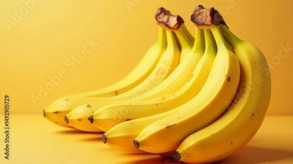 Fototapeta A vibrant bunch of ripe yellow bananas arranged on a matching colored surface