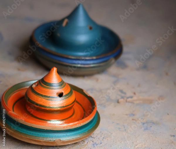 Fototapeta Colorful wet clay art moulded by indian potters and kept for drying with bokeh background of other clay pots.Image for pottery,artwork,workshops,webinars,creation,craft.Complex clay sculpture display