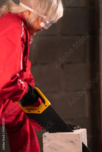 Obraz Side view of a woman cutting bricks.