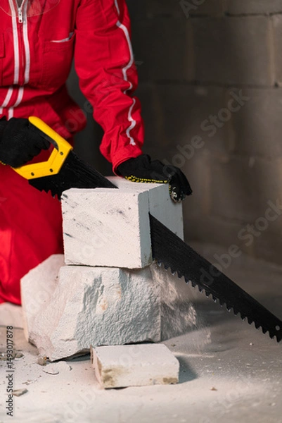 Obraz Flying brick fragments during cutting process.