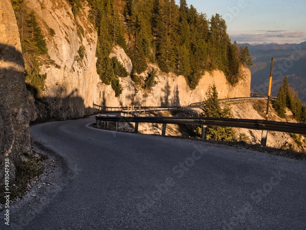 Fototapeta Asphalt road with bends surrounded by rocks and cliffs in a mountains