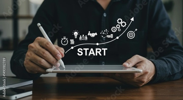 Fototapeta Man using a tablet with stylus, displaying a business start up strategy with icons and upward trend line.