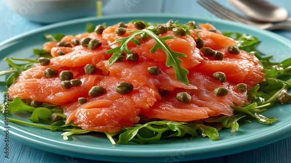 Obraz A dish of raw wild salmon with arugula and capers.