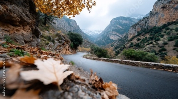 Fototapeta Winding road through a mountain pass, autumn leaves, misty peaks in the distance