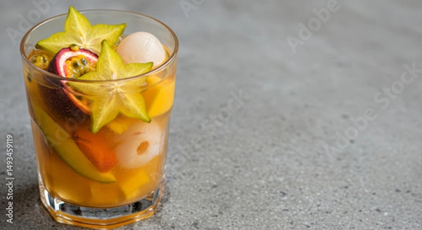 Obraz Colorful tropical fruit cocktail in glass with exotic fruits. Neutral background with copy space for design use.