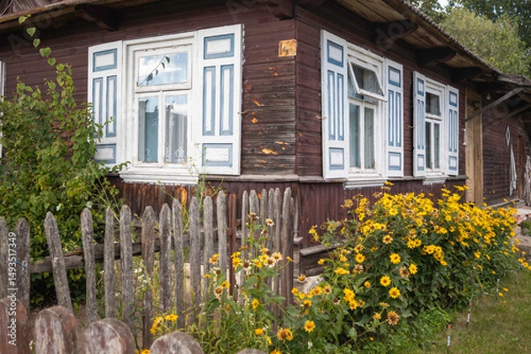 Obraz A house with a white picket fence and a flower garden in front of it