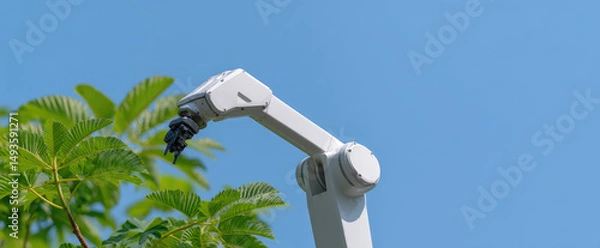 Fototapeta A robotic arm is reaching towards a tree branch under a clear blue sky. Technology and nature interaction