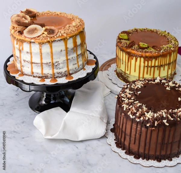 Fototapeta Assorted Gourmet Cakes including Caramel Fig, Pistachio Caramel, and Chocolate cake with napkin side view of assortment of elegant classic desserts