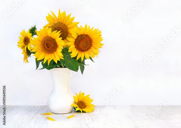 Fototapeta Bouquet of yellow flowers sunflower in porcelain vase on a white wooden table on light background with space for text