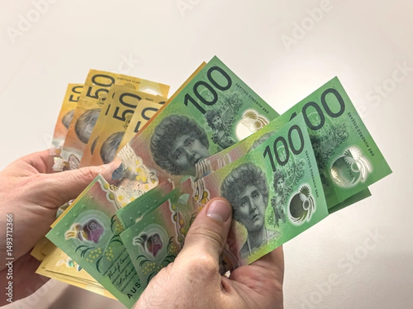 Fototapeta Close-up man hand hold new 50 and 100 Australian dollar banknotes. Saving concept