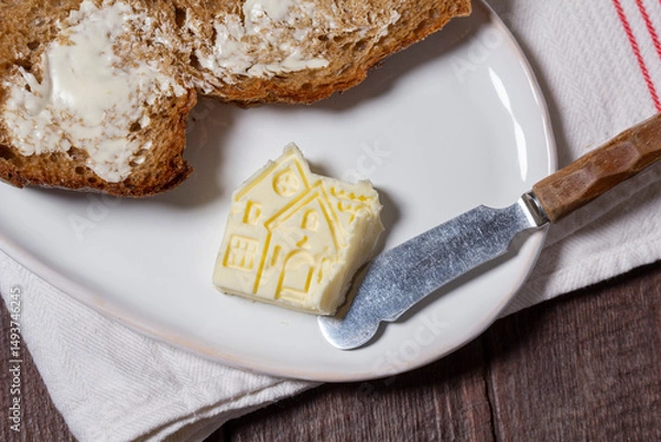 Fototapeta Homemade artisan bread with butter on a light background.