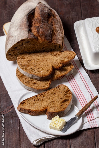 Fototapeta Homemade artisan bread with butter on a light background.