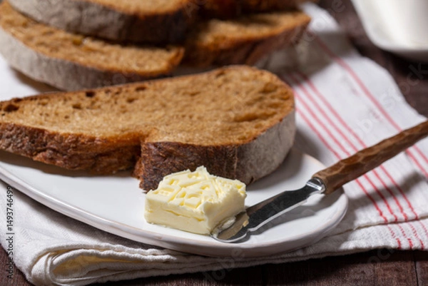 Fototapeta Homemade artisan bread with butter on a light background.