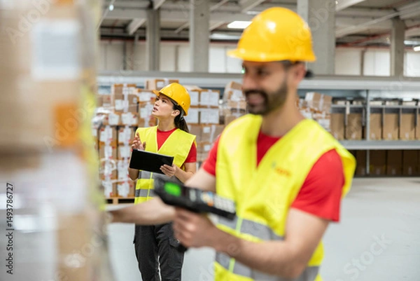 Fototapeta Warehouse workers conduct an inventory check, ensuring accurate tracking and management of products in a busy environment.