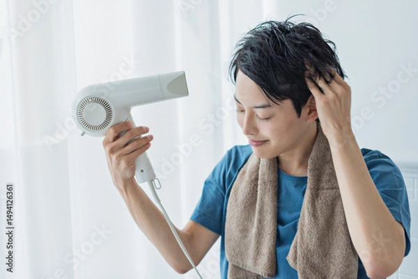 Obraz ドライヤーで髪を乾かす若い男性