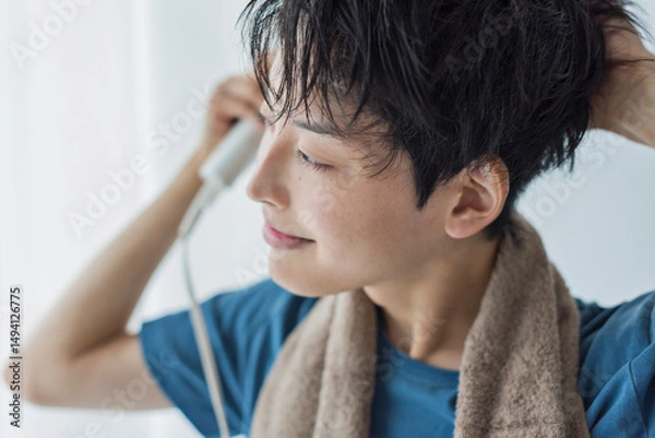 Obraz ドライヤーで髪を乾かす若い男性