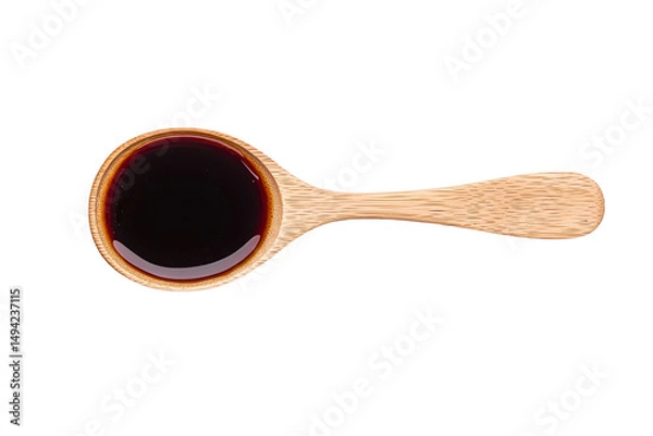 Fototapeta A wooden spoon filled with dark liquid.