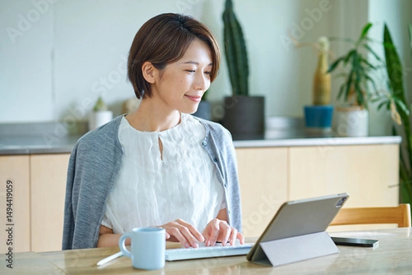 Fototapeta リビングルームで仕事をする女性