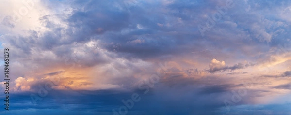 Fototapeta Colorful dramatic clouds during sunset, with layers of light and shadow across the sky. A panoramic view capturing the beauty of changing weather and natural light.