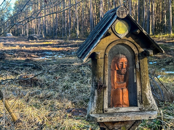 Fototapeta A modest chapel by the road leading through the forest
