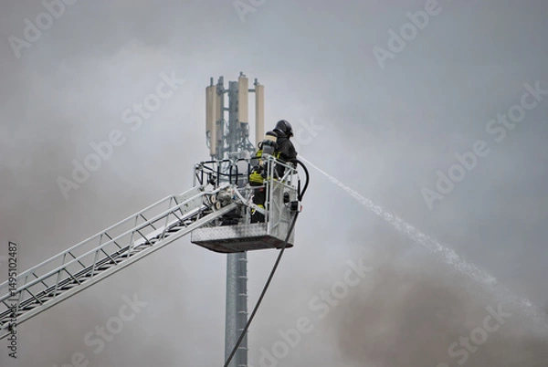Obraz Smoke surrounds the firefighter as he tries to put out the flames