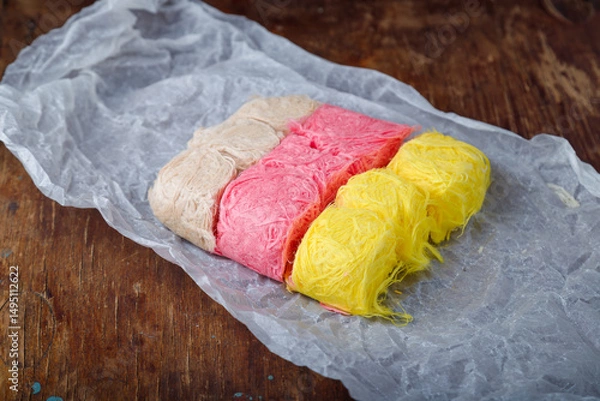 Obraz Multicolored pismaniye or pishmaniye also known as cotton candy, dragons beard or candy floss. Light halva, traditional turkish sweets. Dessert on paper
