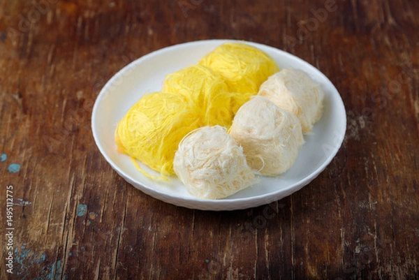 Obraz Pismaniye, cotton candy or dragons beard with vanilla and melon taste on white plate, wooden background. Turkish dessert, light halva, candy floss. Copy space