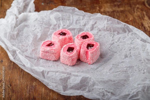 Obraz Turkish delight, pink and white locum roll with walnut and jelly on paper, wooden background. Eastern sweets, oriental food. Traditional tasty dessert