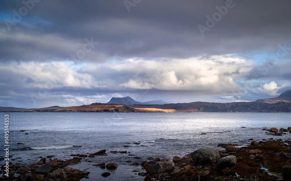 Fototapeta Views out across Gruinard Bay and it's sunlit Islands with the dark cloud covered summit of Beinn Ghobhlach on the North West coast of the Scottish Highlands in the UK