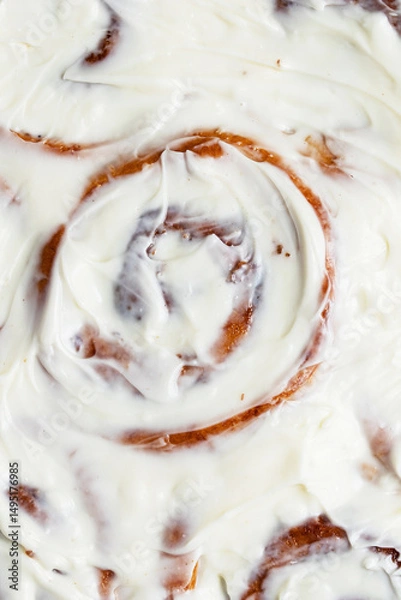 Fototapeta Close up of baked cinnabons with golden crust smeared with cream cheese and cream. Sweet roll buns with cinnamon, yeast pastry. Homemade dessert. Flat lay food. Macro food photography 