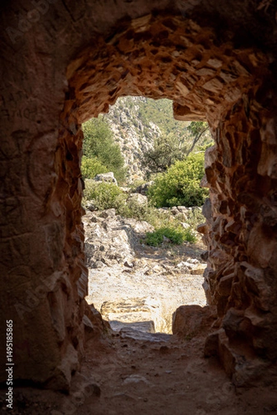 Fototapeta View from inside a medieval stone tower in Vila Velha de Ródão, Portugal, revealing the rugged natural landscape. Captured during summer to highlight historical and architectural heritage.
