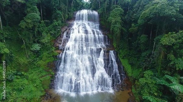 Fototapeta The grand Detian Waterfall cascading down in an impressive series of falls, with water splashing into the pool below surrounded by dense jungle.