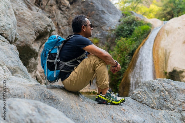 Obraz Hiker resting and admiring waterfall in puebla, mexico