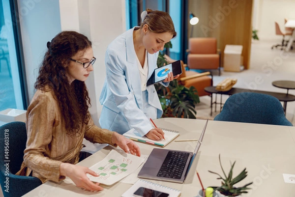 Obraz In a modern office setting, two skilled professionals are engaging in dynamic and creative discussions together