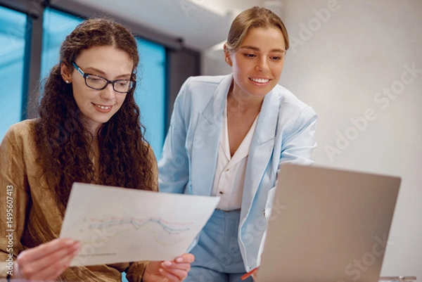 Obraz Two professionals are collaborating in a modern office, analyzing data for impactful decisions and outcomes