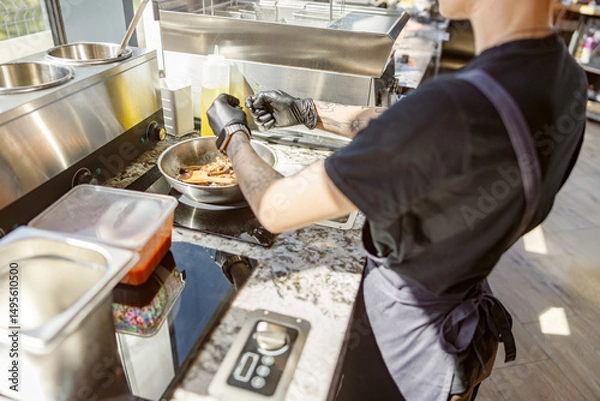 Obraz In a bustling kitchen, a skilled chef prepares a delightful dish while artfully handling fresh ingredients