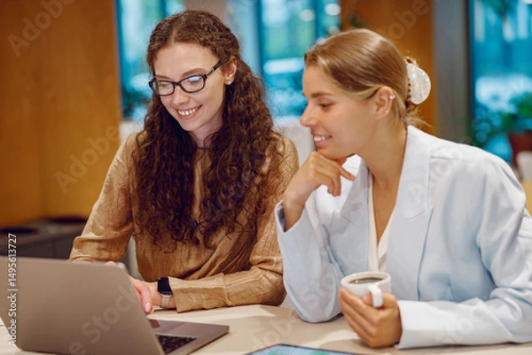 Fototapeta Two dedicated professionals are engaged in a fruitful and productive collaboration within a modern workspace setting