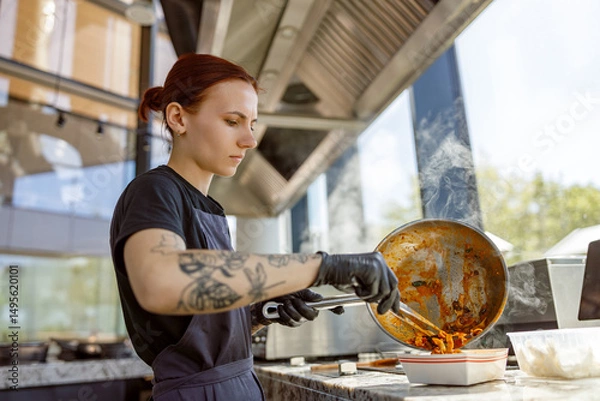 Obraz A skilled chef is expertly preparing a delicious dish in a stylish restaurant kitchen with a unique atmosphere