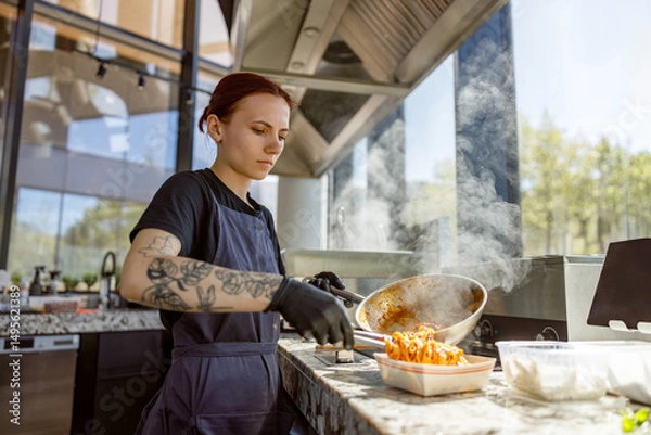 Obraz A skilled and dedicated chef concentrates on crafting a flavorful and delicious dish in a vibrant kitchen environment