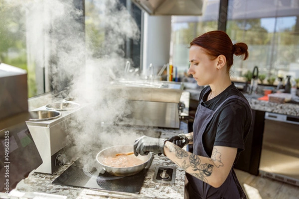 Obraz A skilled chef is preparing a gourmet dish in a stylish kitchen with steam rising gracefully all around