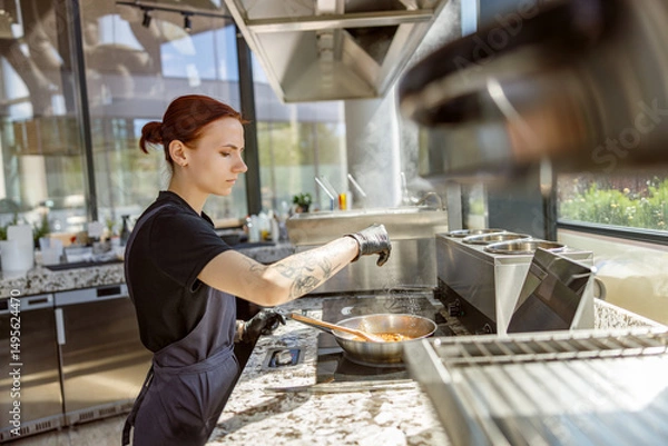 Obraz A highly skilled chef expertly cooks in a beautifully designed contemporary kitchen that is filled with natural light