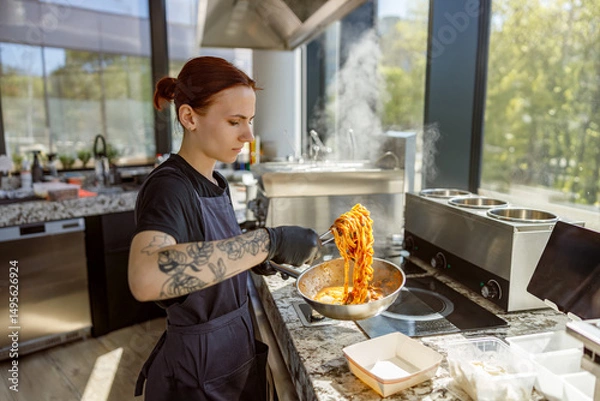 Obraz A skilled chef tosses freshly made pasta in a bright kitchen filled with natural light, creating an energetic vibe